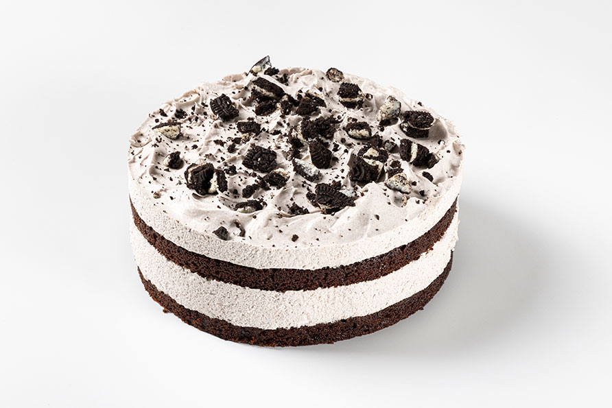 Tarta americana Cookies and Cream con cobertura de crema y trozos de galleta de chocolate.
